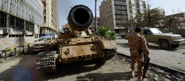 A member of the Libyan pro-government forces, backed by locals, stands near a tank outside the Central Bank, near Benghazi port, January 21, 2015 - Sputnik Mundo