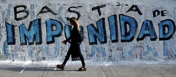 A woman walks in front of graffiti that reads Enough of impunity that was painted before a demonstration outside Argentina's Congress in Buenos Aires February 4, 2015 - Sputnik Mundo