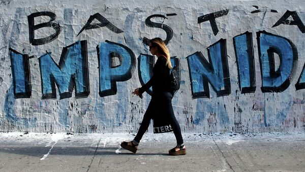 A woman walks in front of graffiti that reads Enough of impunity that was painted before a demonstration outside Argentina's Congress in Buenos Aires February 4, 2015 - Sputnik Mundo