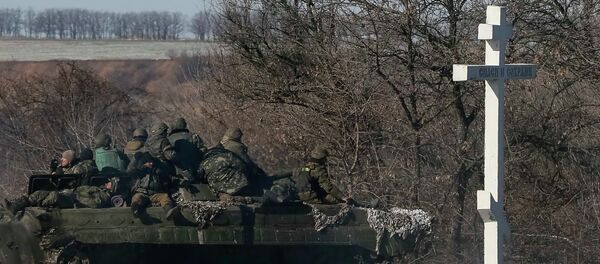 Ukrainian servicemen ride on a military vehicle as they leave an area around Debaltseve, February 18, 2015 - Sputnik Mundo