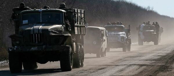 Ukrainian servicemen ride on military vehicles as they leave an area around Debaltseve, eastern Ukraine near Artemivsk, February 18, 2015. - Sputnik Mundo