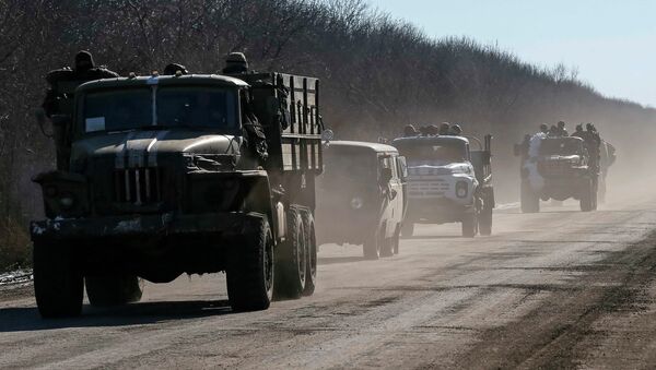 Ukrainian servicemen ride on military vehicles as they leave an area around Debaltseve, eastern Ukraine near Artemivsk, February 18, 2015. - Sputnik Mundo