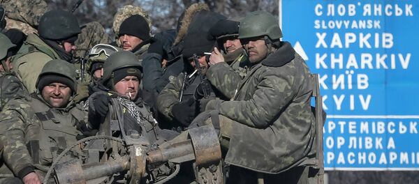 Ukrainian servicemen ride on a military vehicle as they leave the area around Debaltseve, February 18, 2015 - Sputnik Mundo