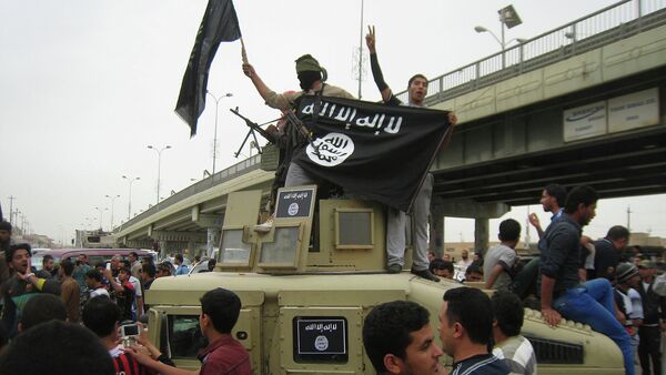 In this file photo, Islamic State group militants hold up their flag as they patrol in a commandeered Iraqi military vehicle in Fallujah, 40 miles (65 kilometers) west of Baghdad, Iraq - Sputnik Mundo