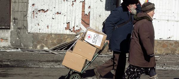 A man walking with a woman pulls a trolley with International Committee of the Red Cross relief packages in the town of Debaltseve February 22, 2015 A man walking with a woman pulls a trolley with International Committee of the Red Cross relief packages in the town of Debaltseve February 22, 2015 - Sputnik Mundo