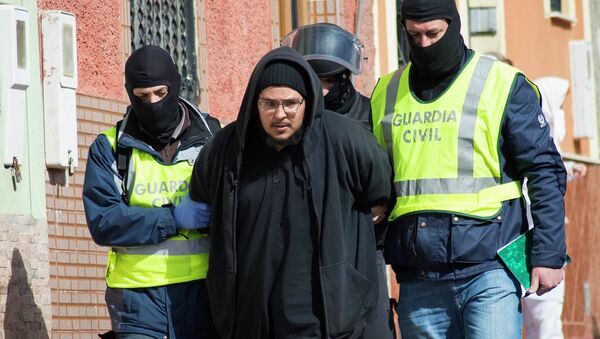 Spanish civil guards lead a detained man suspected of using social media to recruit people to violent groups like the Islamic State, in Spain's North African enclave Melilla, February 24, 2015 Spanish civil guards lead a detained man suspected of using social media to recruit people to violent groups like the Islamic State, in Spain's North African enclave Melilla, February 24, 2015 - Sputnik Mundo