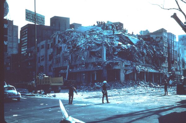 Brigadas de rescate trabajando sobre un edificio colapsado en el centro de México Brigadas de rescate trabajando sobre un edificio colapsado en el centro de México - Sputnik Mundo