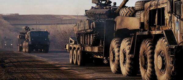 Military trucks from the Ukrainian armed forces transport tanks on the road near Artemivsk, eastern Ukraine, February 24, 2015 - Sputnik Mundo