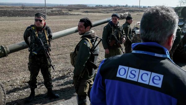 A member of Special Monitoring Mission of the OSCE to Ukraine walks along a convoy of Ukrainian armed forces in Blagodatne, eastern Ukraine, February 27, 2015 - Sputnik Mundo