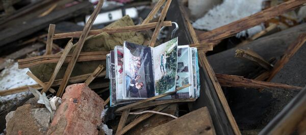 Album de fotos de la familia se ve en las ruinas de una casa en un barrio cerca de Donetsk - Sputnik Mundo