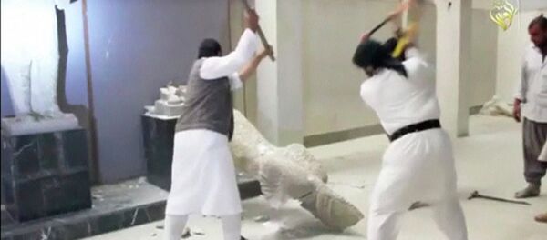 Men use sledgehammers on a toppled statue in a museum at a location said to be Mosul - Sputnik Mundo