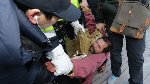 Security personnel detain Kim Ki-jong, a member of a pro-Korean unification group who attacked the U.S. ambassador to South Korea Mark Lippert at a public forum, in central Seoul March 5, 2015 - Sputnik Mundo