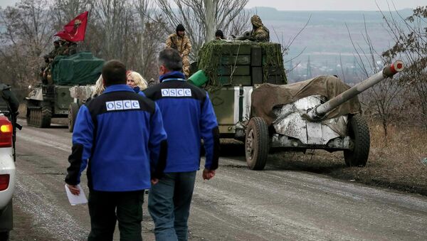 Members of Special Monitoring Mission of the OSCE to Ukraine walk along a convoy of Ukrainian armed forces in Paraskoviyvka, eastern Ukraine, February 26, 2015 - Sputnik Mundo