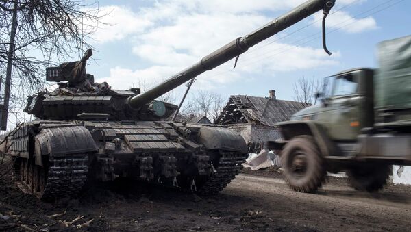 A truck passes by a pro-Russian rebel's tank with a gas mask placed on it's barrel in the village of Molochnoye, north-east from Donetsk, March 8, 2015 - Sputnik Mundo