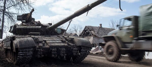 A truck passes by a pro-Russian rebel's tank with a gas mask placed on it's barrel in the village of Molochnoye, north-east from Donetsk, March 8, 2015 - Sputnik Mundo