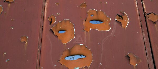 A gate filled with shrapnel holes is pictured in Donetsk's Oktyabrski district - Sputnik Mundo