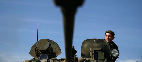 Soldado ucraniano mira desde un vehículo blindado - Sputnik Mundo