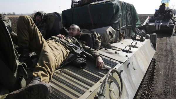 Ukranian servicemen rest on top of an Armoured Personnel Carriers ferrying cannons from their position near eastern Ukrainian city of Soledar - Sputnik Mundo