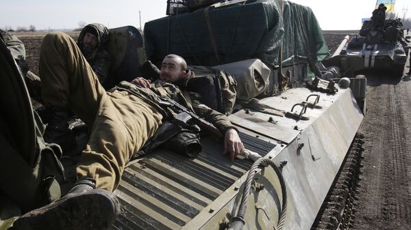 Ukranian servicemen rest on top of an Armoured Personnel Carriers ferrying cannons from their position near eastern Ukrainian city of Soledar - Sputnik Mundo