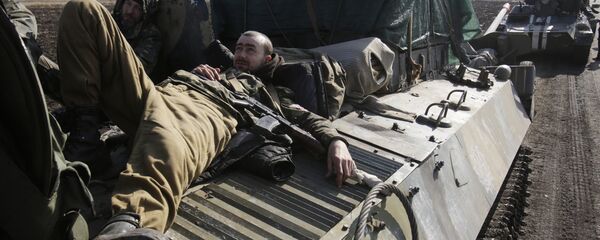 Ukranian servicemen rest on top of an Armoured Personnel Carriers ferrying cannons from their position near eastern Ukrainian city of Soledar - Sputnik Mundo