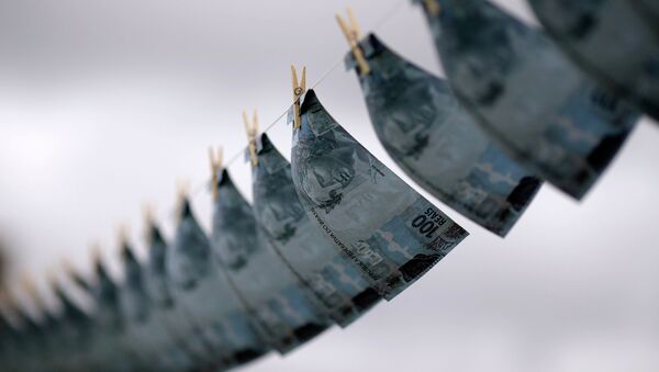 Replicas of R$100,00 banknotes are hung on a clothesline during a protest against money laundering in Brazil, in Brasilia March 18, 2015 - Sputnik Mundo