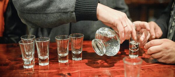 Una persona llenando vasos de alcohol - Sputnik Mundo