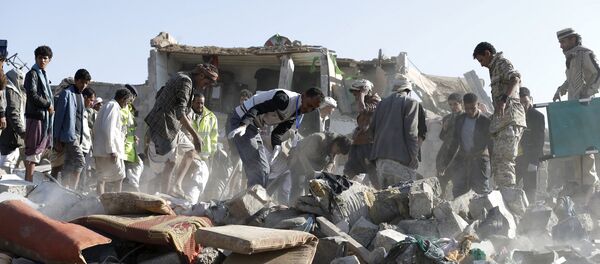 Personas desmontan las ruinas después del ataque aéreo en la capital de Yemen, Saná - Sputnik Mundo
