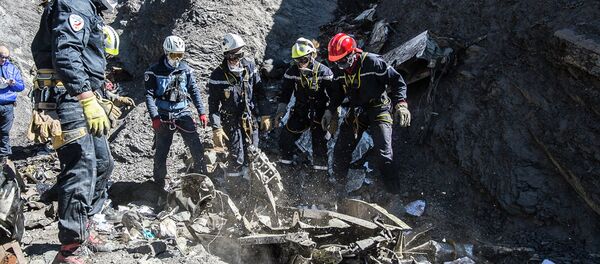 Resuce workers and investigators, seen in this picture made available to the media by the French Interior Ministry April 1, 2015, work near debris from wreckage at the crash site of a Germanwings Airbus A320, near Seyne-les-Alpes - Sputnik Mundo