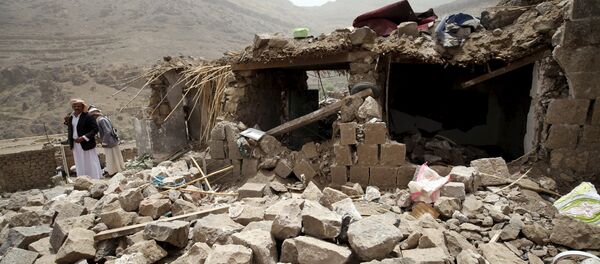 People stand on the rubble of houses destroyed by an air strike in the Okash village near Sanaa April 4, 2015. People stand on the rubble of houses destroyed by an air strike in the Okash village near Sanaa April 4, 2015. - Sputnik Mundo
