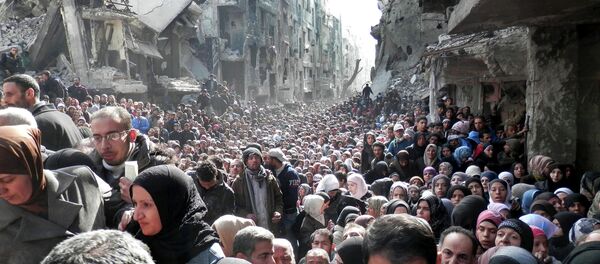 Residentes del campo de refugiados palestinos Yarmuk hacen cola para recibir alimentos (archivo) - Sputnik Mundo