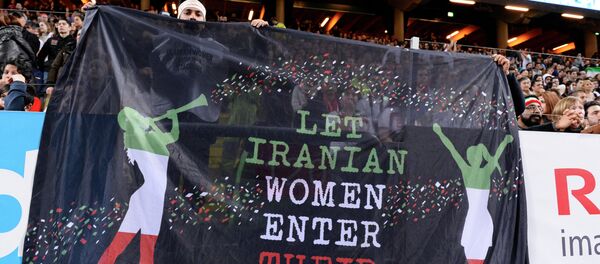 Hinchas sostienen una pancarta que dice 'Que las mujeres iraníes entren en sus estadios' durante el partido amistoso de fútbol entre Suecia e Irán - Sputnik Mundo