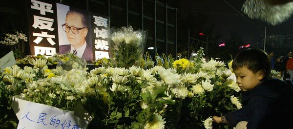 A boy lays down a flower at a candle lit memorial service for purged Chinese leader Zhao Ziyang in Hong Kong 21 January 2005. - Sputnik Mundo