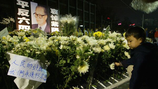 A boy lays down a flower at a candle lit memorial service for purged Chinese leader Zhao Ziyang in Hong Kong 21 January 2005. - Sputnik Mundo