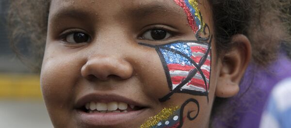 A Venezuelan girl, with her face painted with a crossed-out U.S. flag, looks on during the traditional Burning of the Judas as part of Easter celebrations in Caracas April 5, 2015. - Sputnik Mundo