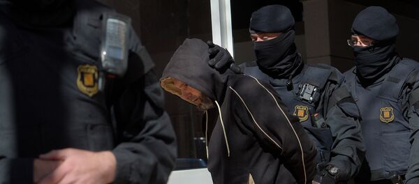 Mossos d'Esquadra custodian a uno de los detenidos en Sabadell - Sputnik Mundo
