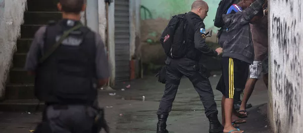A police officer searches residents in Alemao slum complex as part of a security reinforcement by the UPP (Police Pacification Unit) in Rio de Janeiro A police officer searches residents in Alemao slum complex as part of a security reinforcement by the UPP (Police Pacification Unit) in Rio de Janeiro - Sputnik Mundo