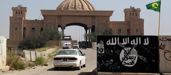 Bandera del EI pintada en una muralla cerca del Palacio de Saddam Hussein in Tikrit - Sputnik Mundo