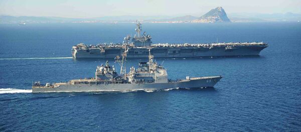 The Ticonderoga-class guided missile cruiser USS Vicksburg escorts the Nimitz-class aircraft carrier USS Theodore Roosevelt (top) as they pass the Rock of Gibraltar in the Mediterranean Sea - Sputnik Mundo