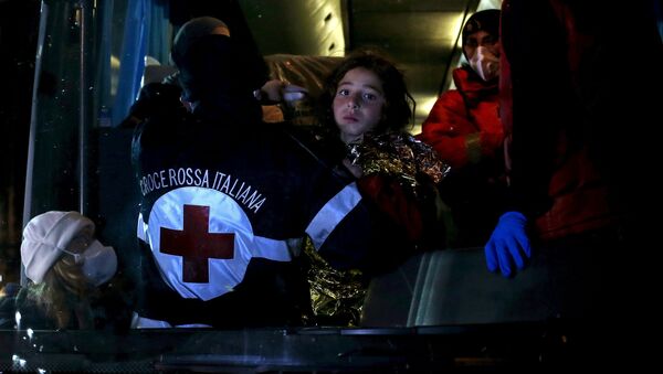 A child (C) is carried into bus as migrants arrive via boat at the Sicilian harbor of Pozzallo April 20, 2015. - Sputnik Mundo