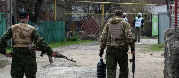 Pro-Russian separatists walk in a street patrolled by OSCE observers in the village of Shyrokyne - Sputnik Mundo