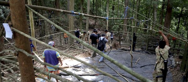 Fuerzas de seguridad y los equipos de rescate inspeccionan en el campamento abandonado en una selva en Tailandia - Sputnik Mundo