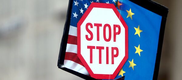 A protester holds signs during a demonstration against the Transatlantic Trade and Investment Partnership (TTIP), a proposed free trade agreement between the European Union and the United States, in Munich April 18, 2015. A protester holds signs during a demonstration against the Transatlantic Trade and Investment Partnership (TTIP), a proposed free trade agreement between the European Union and the United States, in Munich April 18, 2015. - Sputnik Mundo