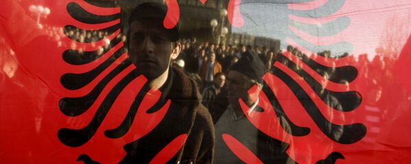 Kosovo Albanians are seen through the Albanian flag during a protest in Pristina on December 2, 2008 - Sputnik Mundo