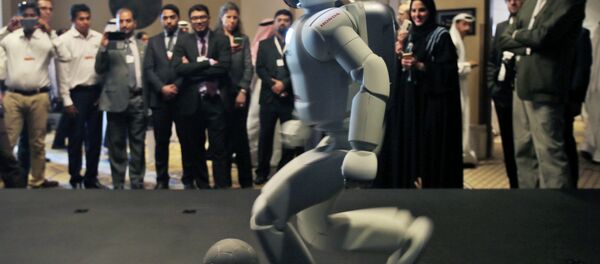 A humanoid robot designed and developed by Honda and named Asimo plays football for the audience at the end of the company's presentation during the last day of the Government Summit in Dubai, United Arab Emirates, Wednesday, Feb. 11, 2015 - Sputnik Mundo