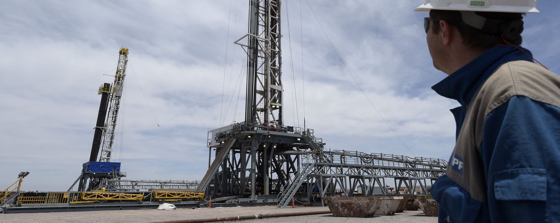 Argentinian oil company YPF's drilling chief Martin Costa observes two oil drilling rigs at his charge in Vaca Muerta Shale oil reservoir at Loma Campana - Sputnik Mundo, 1920, 12.02.2022