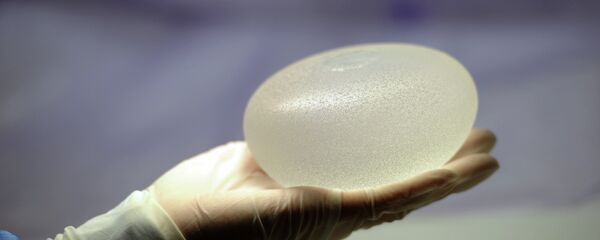 A picture taken on January 12, 2012 in Boissy-l'Aillerie, northern Paris, shows a technician presenting a silicone breast implant - Sputnik Mundo