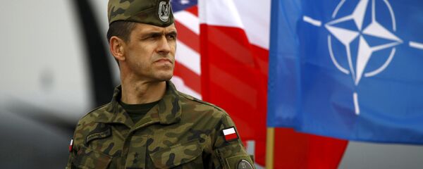 Soldado polaco al lado de las banderas nacionales de los EEUU y Polonia y la bandera de la OTAN - Sputnik Mundo
