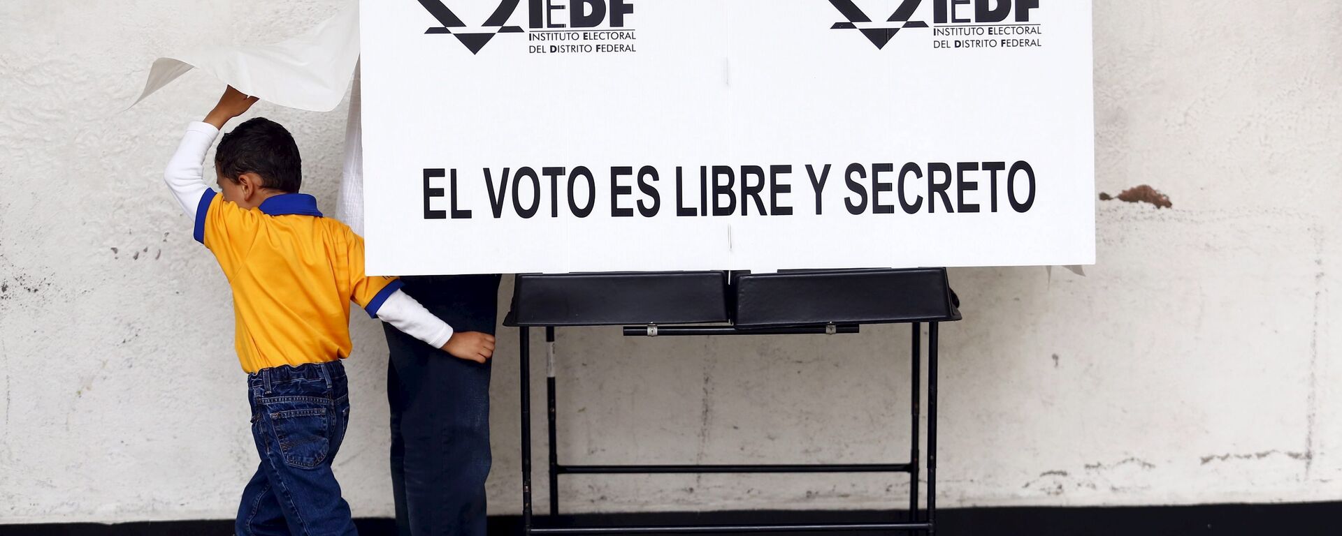 A man casts his ballot next to his son during midterm elections in Mexico City, June 7, 2015.  - Sputnik Mundo, 1920, 05.06.2021