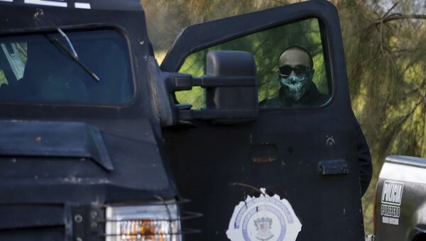 A police officer stands guard inside a ranch where a firefight took place on Friday in Tanhuato, state of Michoacan, May 23, 2015 - Sputnik Mundo