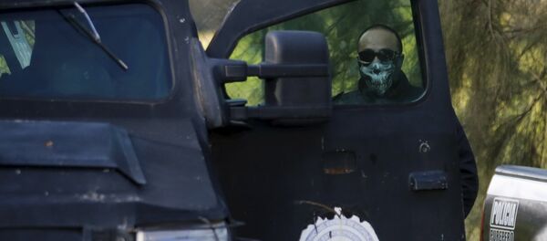 A police officer stands guard inside a ranch where a firefight took place on Friday in Tanhuato, state of Michoacan, May 23, 2015 - Sputnik Mundo